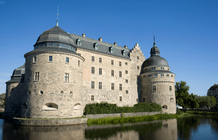 Das imposante Schloss von Örebro spiegelt sich im Wasser des Svartån Flusses