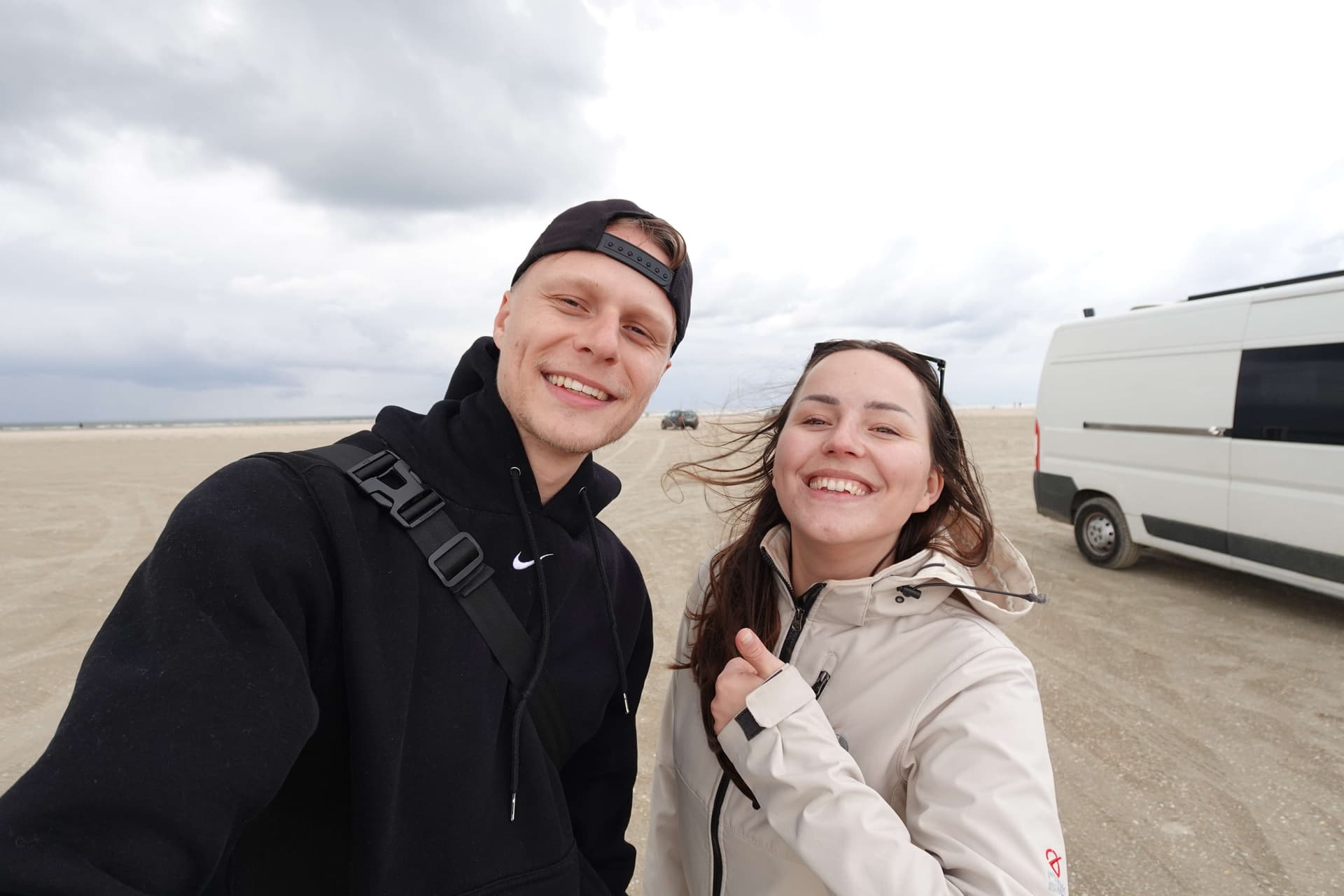 Lara und Mark am Strand von Rømø mit ihrem Campervan im Hintergrund