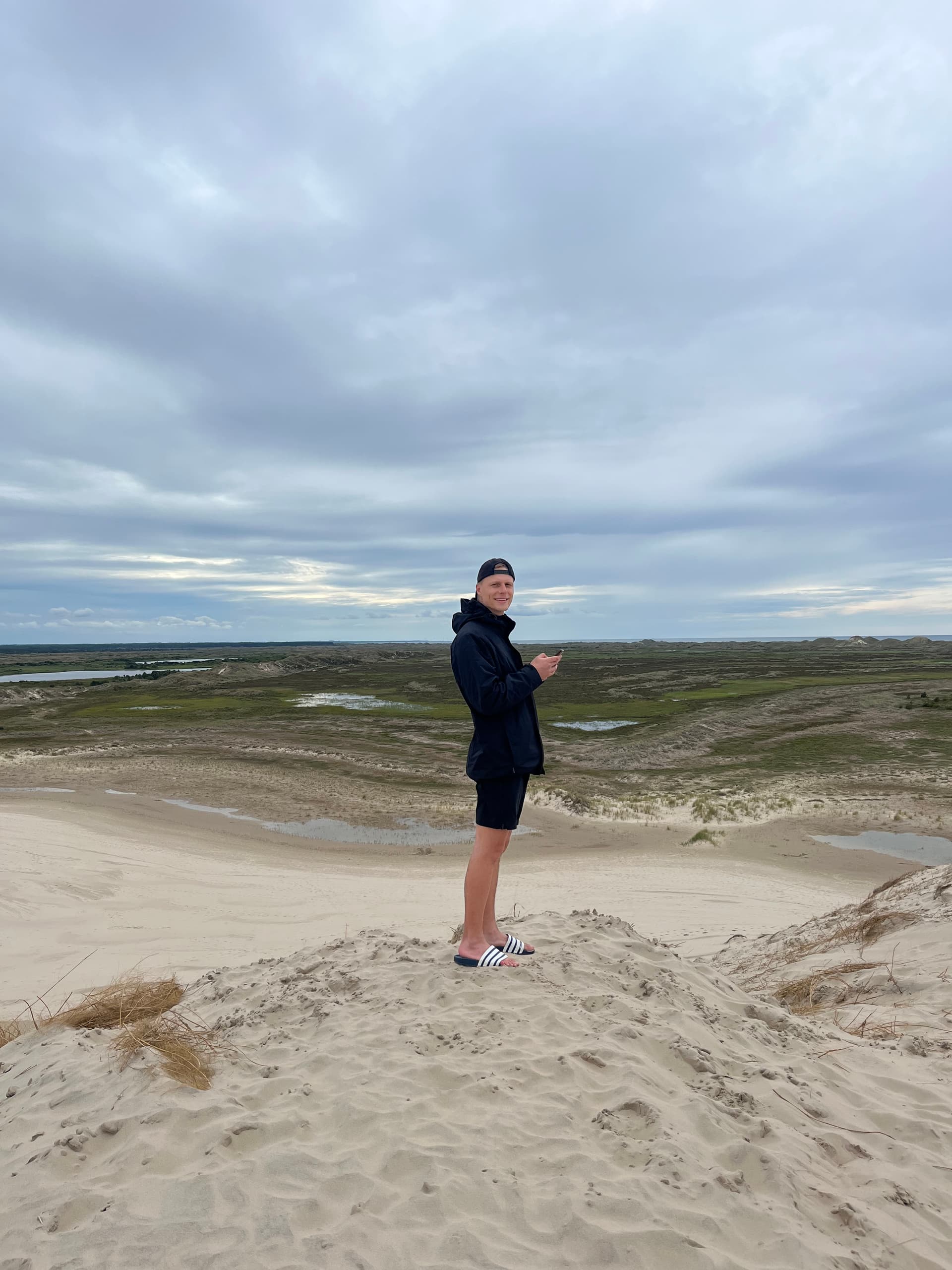 Person steht auf der Wanderdüne Råbjerg Mile in Skagen mit Blick über die weitläufige Dünenlandschaft