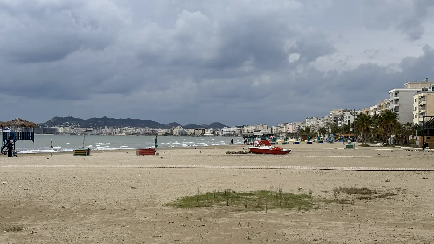 Leerer Sandstrand von Durrës bei bewölktem Himmel, im Hintergrund die Hochhäuser der Stadt