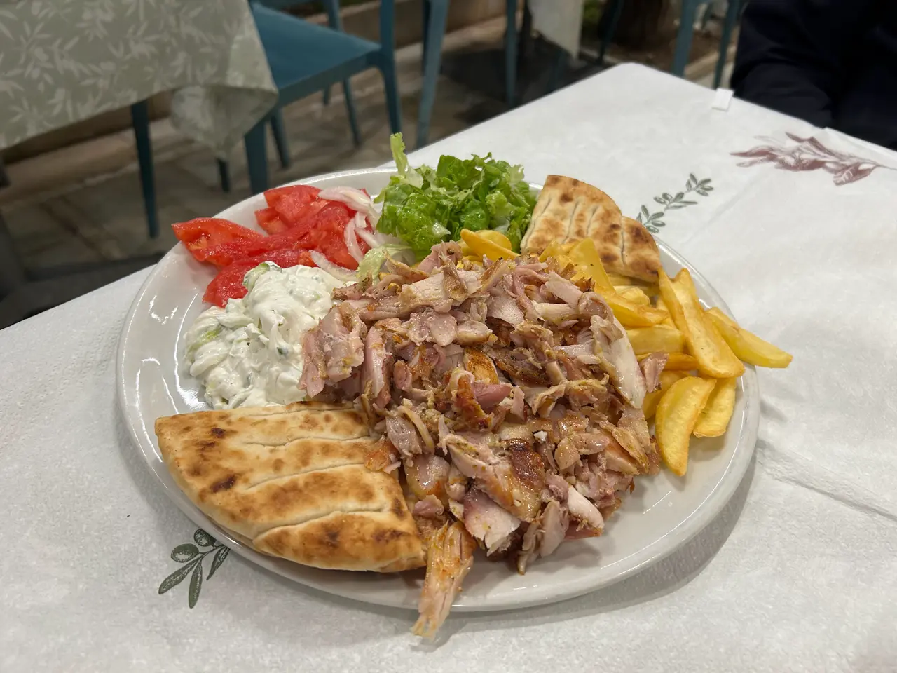 Gyros-Teller mit Pommes, Fladenbrot und Tzatziki in einem Restaurant an der Promenade von Saranda