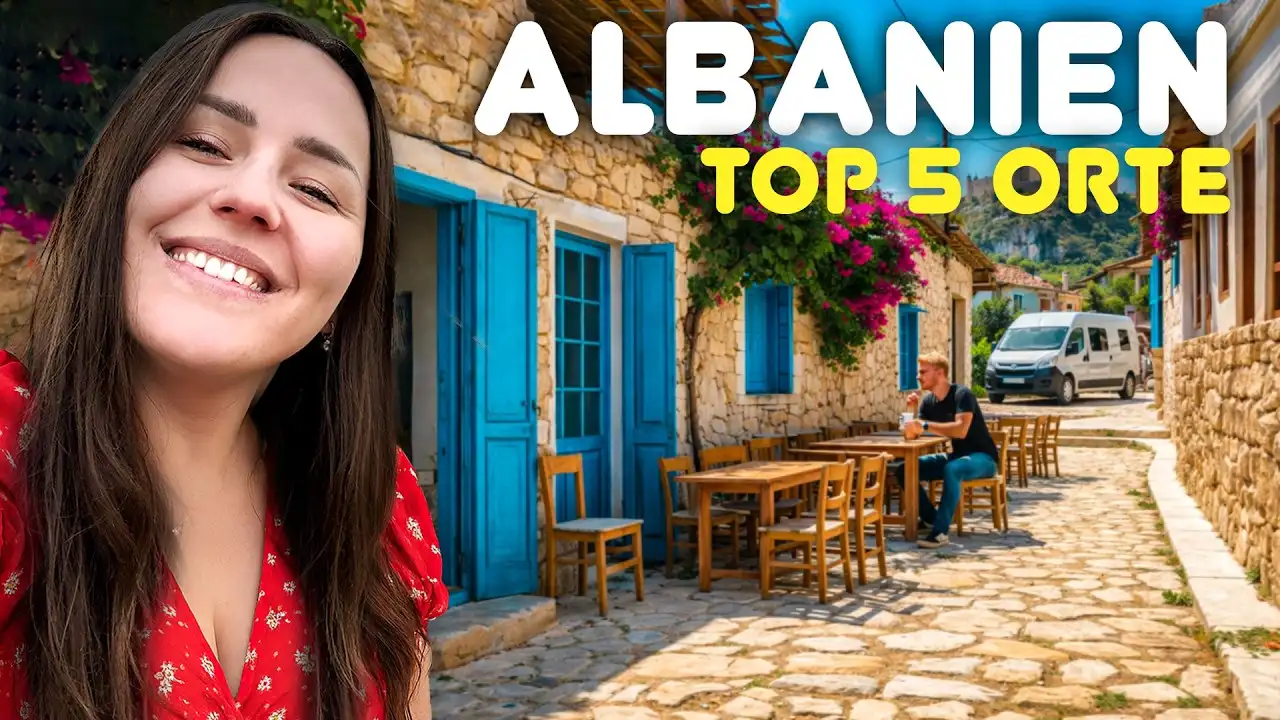 Titelbild unseres Videos „Albanien Top 5 Orte“: Lara lächelt in die Kamera, dahinter eine Gasse mit blauen Türen und ein Campervan