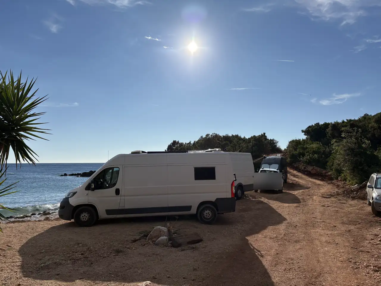 Mehrere Camper und Autos nebeneinander an einem Kiesstrand an der albanischen Riviera