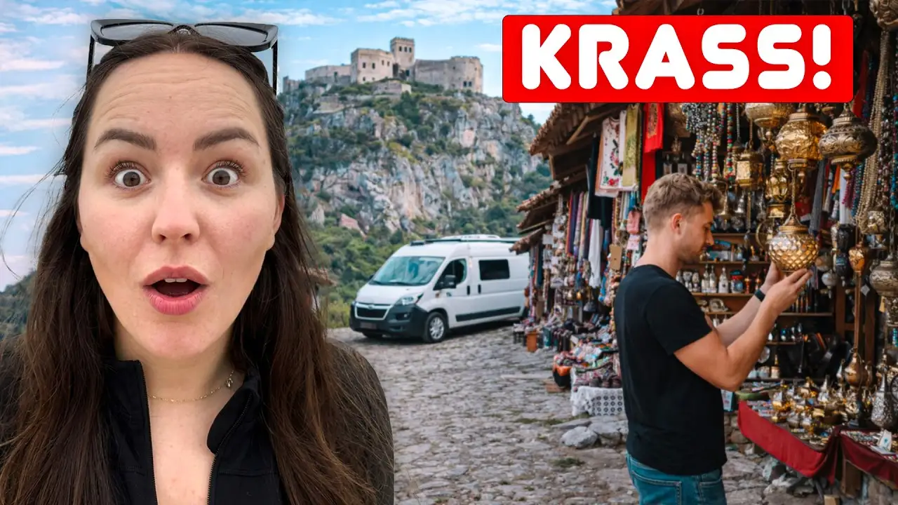 Titelbild unseres Kruja-Videos: Lara staunend vor dem Basar, daneben Mark an einem Stand, dahinter die Festung auf dem Felsen