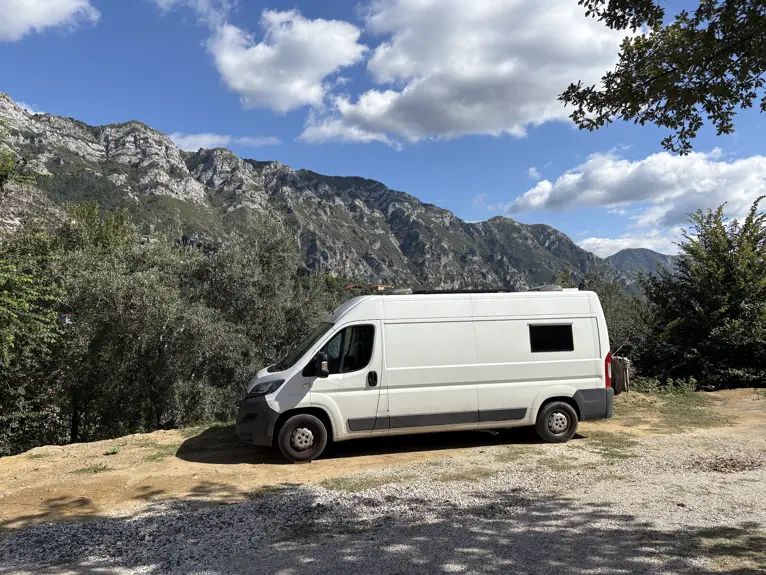 Unser weißer Campervan auf dem Kruja Vista Camping vor den Bergen oberhalb von Kruja