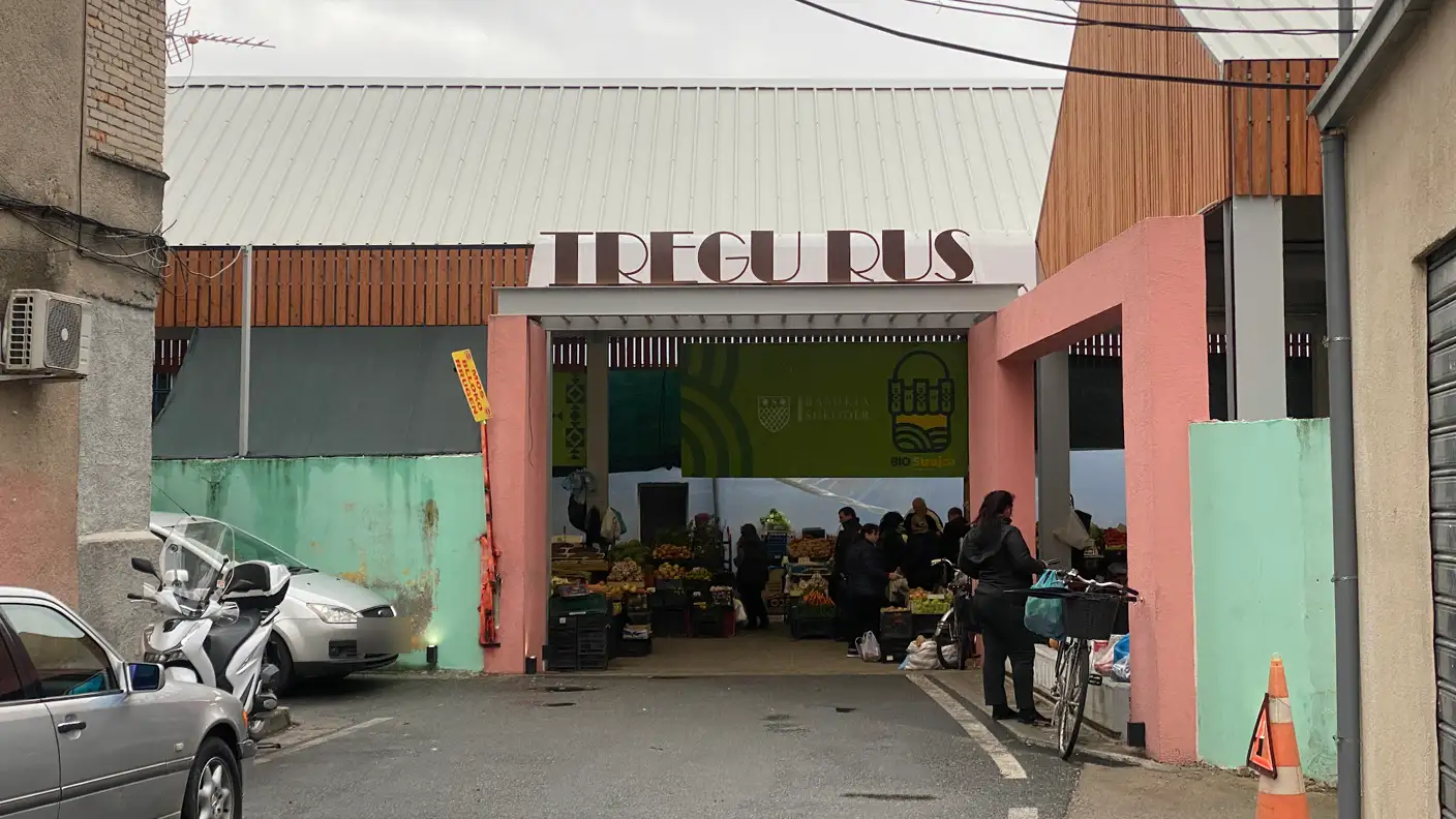 Eingang zum Markt Tregu Rus in Shkodra mit Schriftzug über dem Tor und Obstständen in der Halle