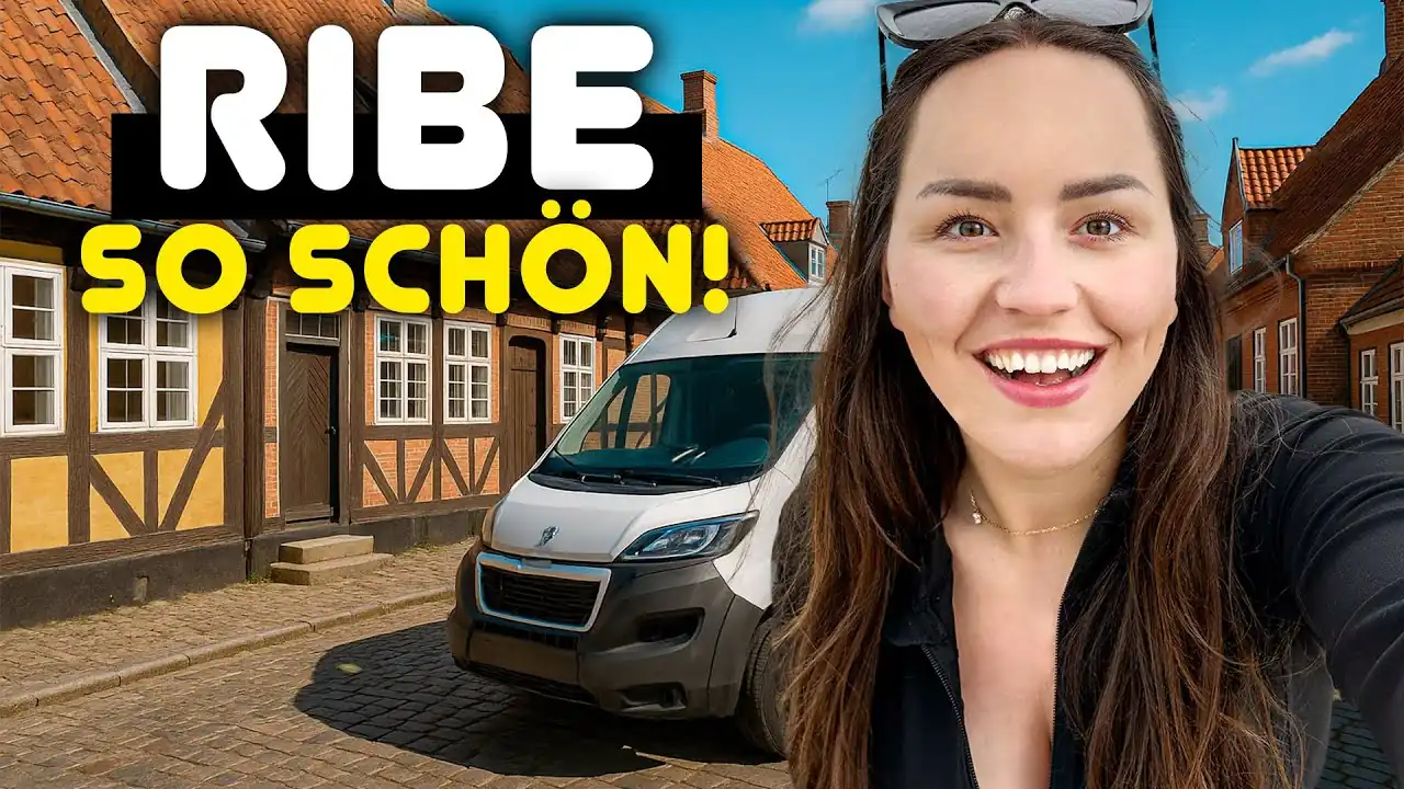 Lara von Lehmann Vlogs vor unserem Kastenwagen in einer Kopfsteinpflastergasse mit Fachwerkhäusern in Ribe