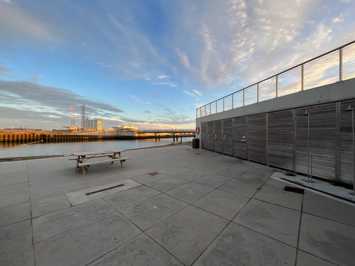 Badeplattform am Esbjerg Strand im Abendlicht mit Picknickbank und Umkleidekabinen