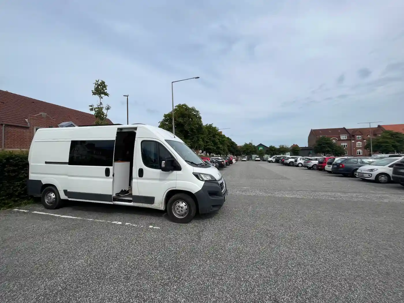 Unser weißer Kastenwagen mit offener Schiebetür auf einem Parkplatz in der Innenstadt von Esbjerg