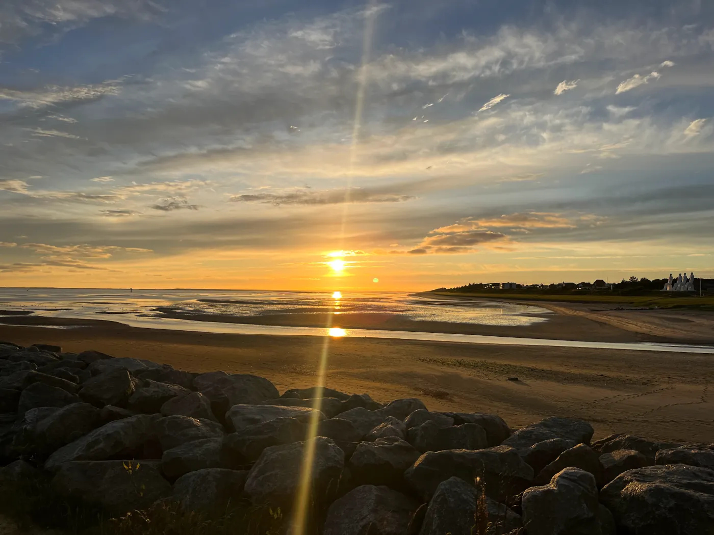Sonnenuntergang über dem Wattenmeer bei Esbjerg, rechts am Horizont die vier weißen Figuren von Der Mensch am Meer