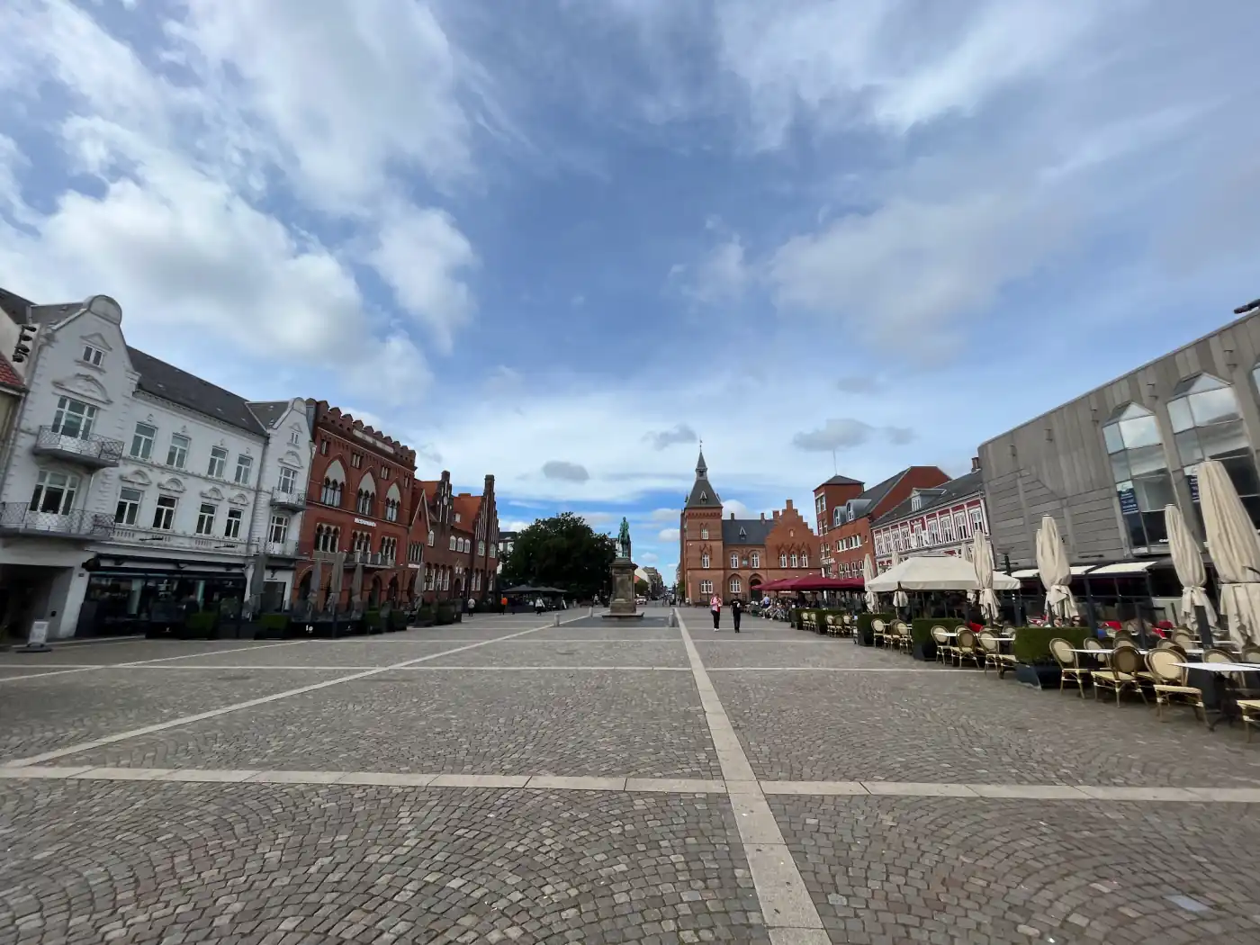 Der weite gepflasterte Marktplatz Torvet in Esbjerg mit roten Backsteinhäusern und Cafétischen