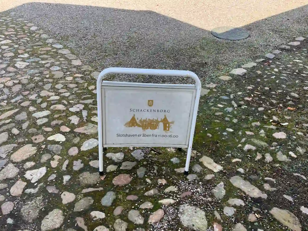 Hinweistafel am Schloss Schackenborg mit den Öffnungszeiten des Schlossgartens