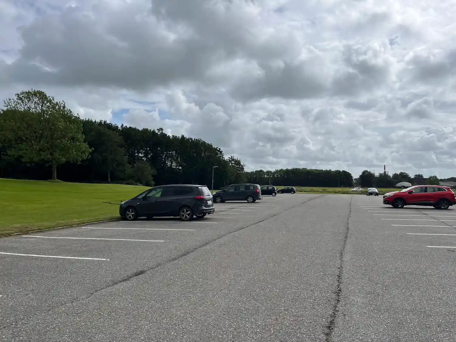 Parkfläche in Tondern mit einzelnen Autos und Grünstreifen am Rand