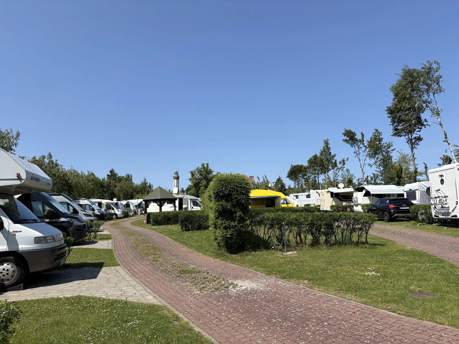 Campingplatz in Niechorze mit Blick auf den Leuchtturm zwischen den Bäumen