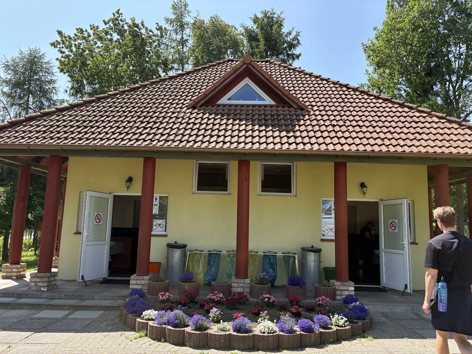 Sanitärgebäude auf Camping Pomona mit Blumenbeeten am Eingang