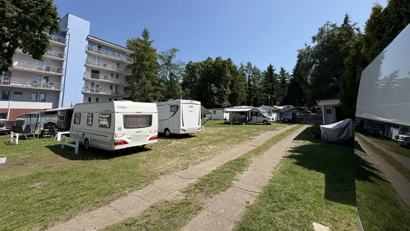Campingplatz Camping Plaża in Misdroy mit Wohnwagen und Wohnmobilen auf engen Rasenparzellen vor einem Hotelgebäude