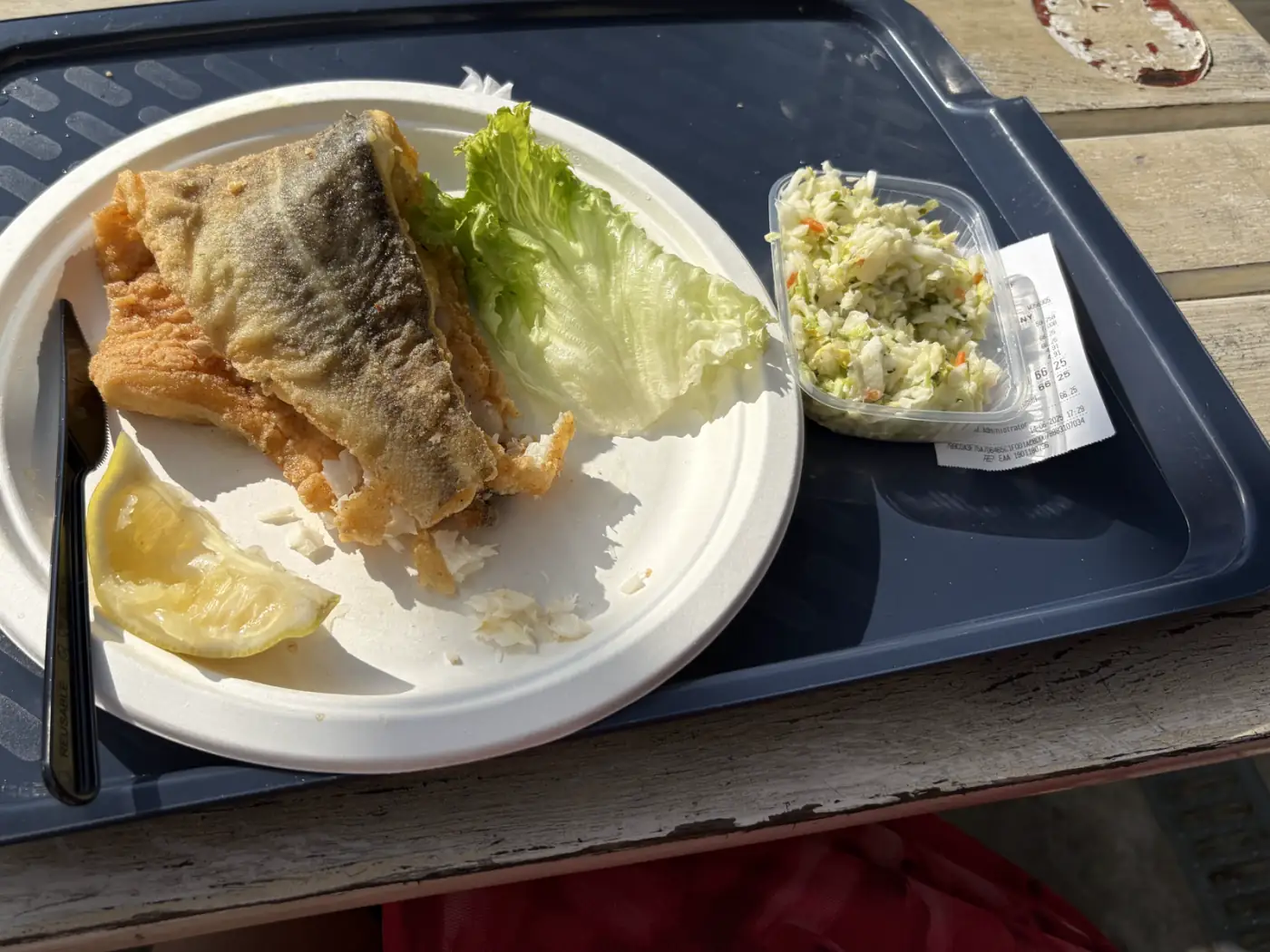 Gebratenes Fischfilet mit Salat und Zitrone auf einem Tablett in einer Fischbraterei am Fischerhafen von Misdroy