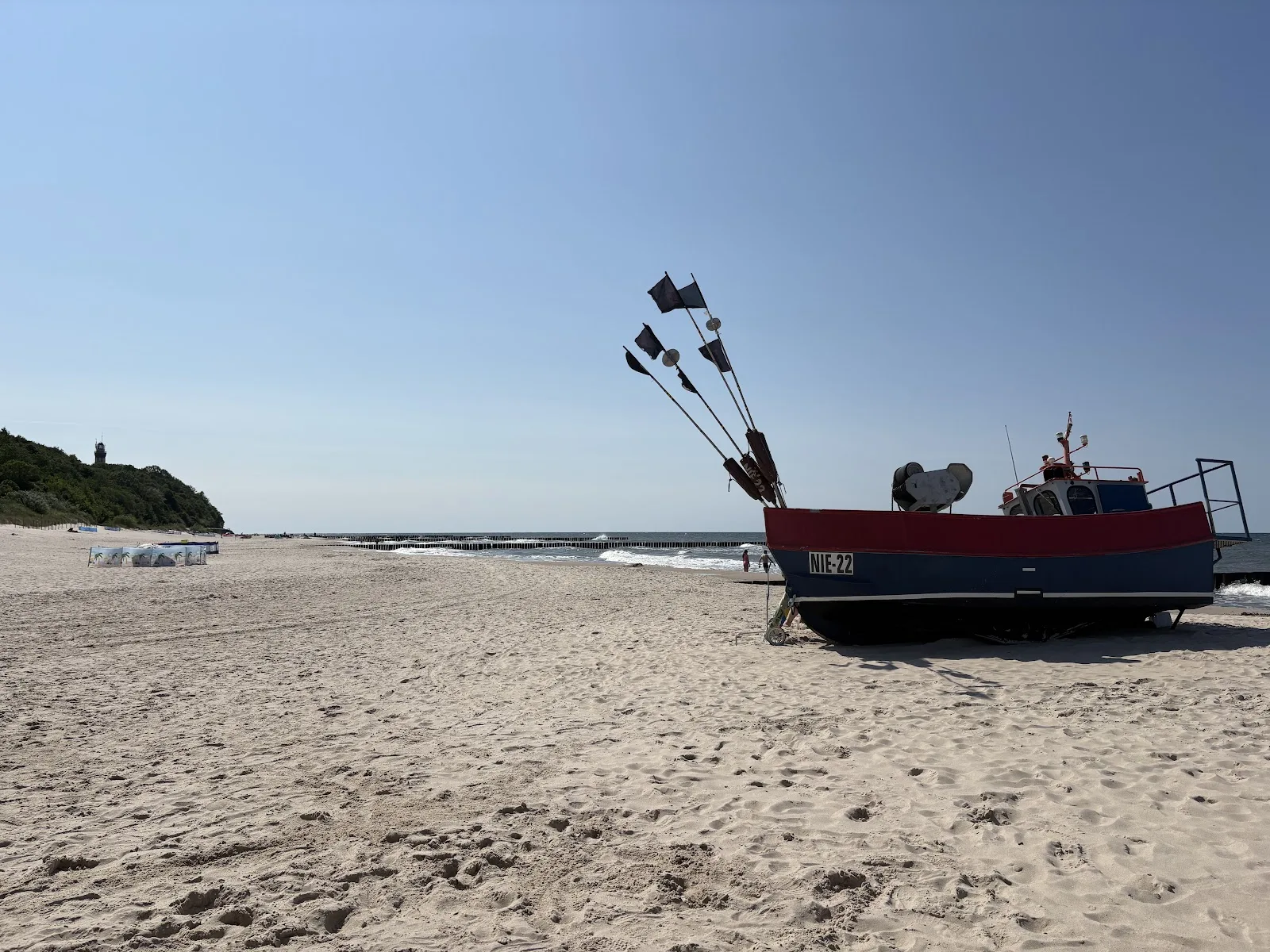Fischerboot am Sandstrand von Niechorze mit Blick auf den Leuchtturm