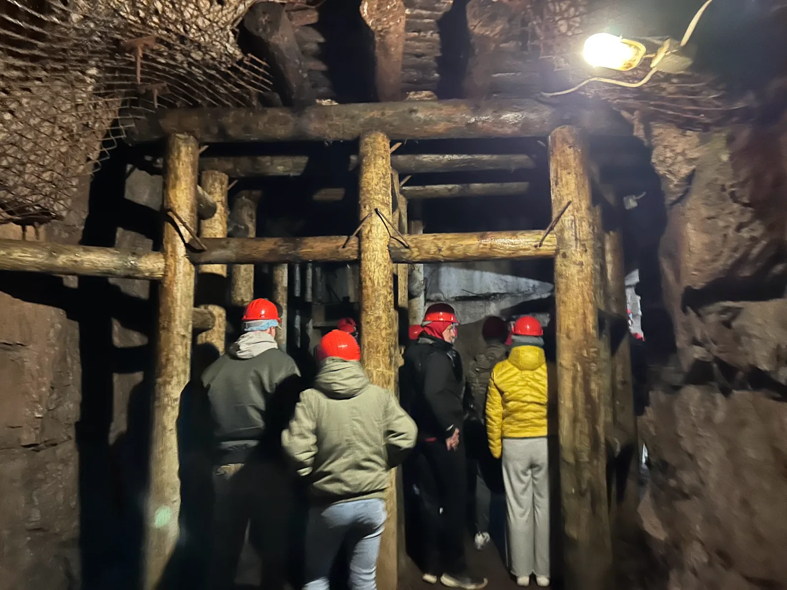 Besuchergruppe mit Helmen in einem Tunnelabschnitt von Projekt Riese im Eulengebirge