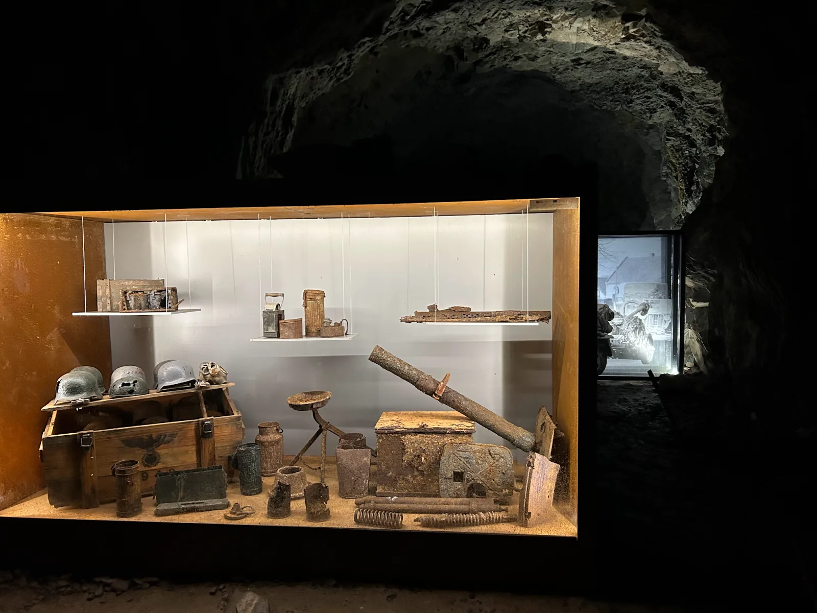 Museum-Vitrine im Projekt Riese Osówka mit Original-Wehrmachts-Helmen, Munitionskisten und Werkzeugen