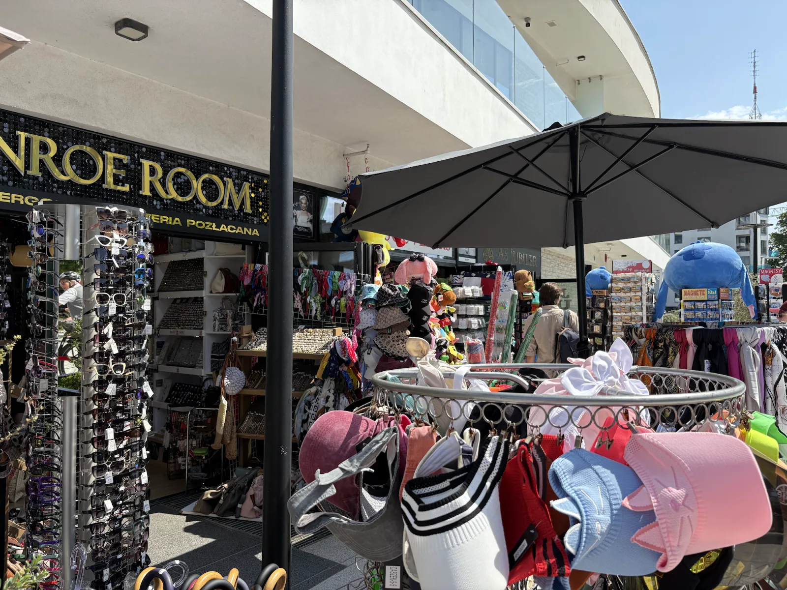Souvenirstand auf der Swinemünde-Promenade mit Sonnenbrillen, Hüten und Boules-Kugeln