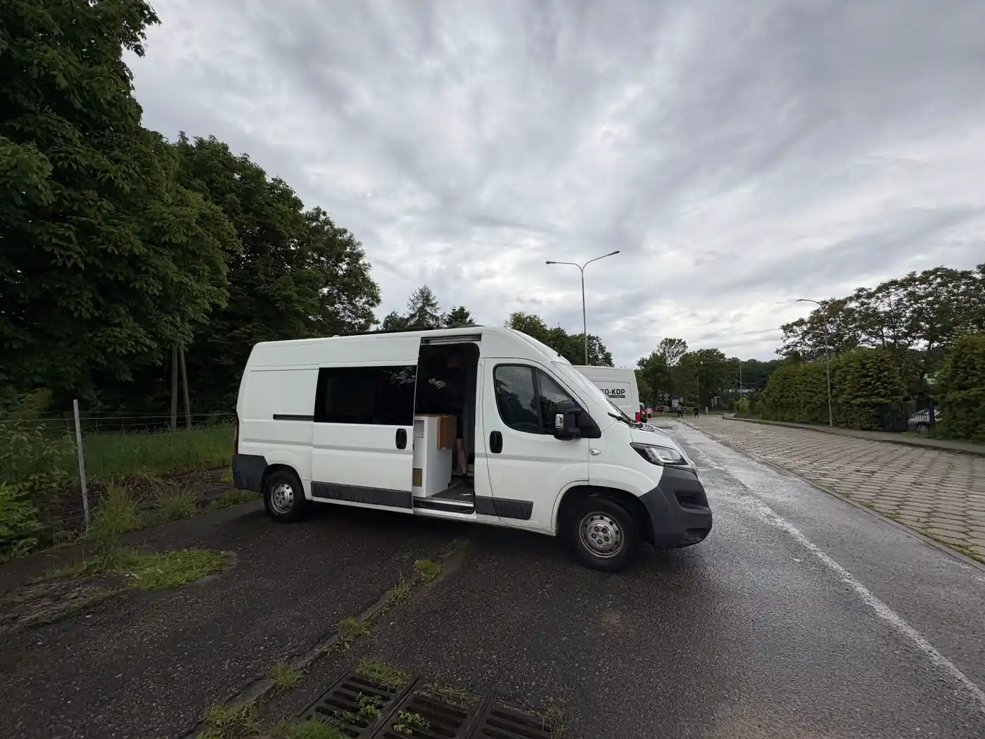 Kastenwagen mit offener Schiebetür auf einem Parkplatz in Polen