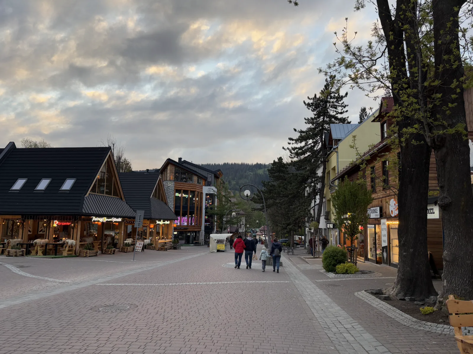 Krupówki Fußgängerzone in Zakopane mit Goralen-Restaurants und Familie am Abend