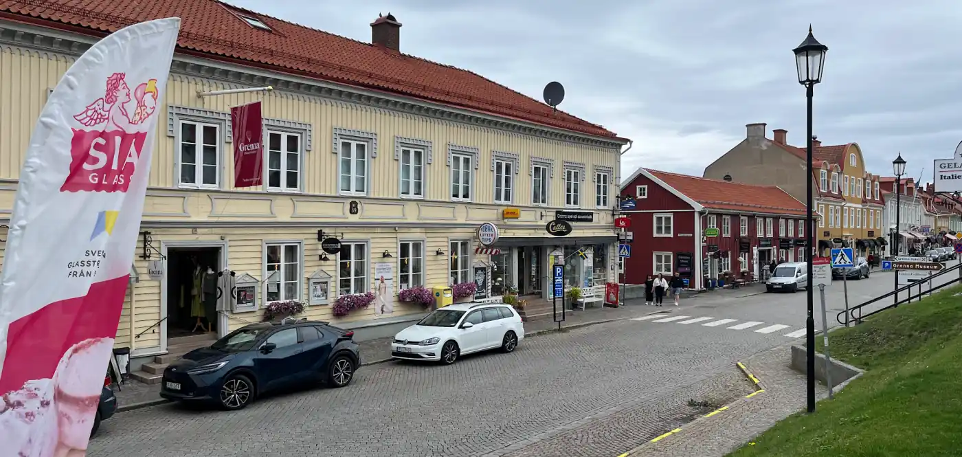 Die Hauptstraße von Gränna mit gelben und roten Holzhäusern, Kopfsteinpflaster und Läden