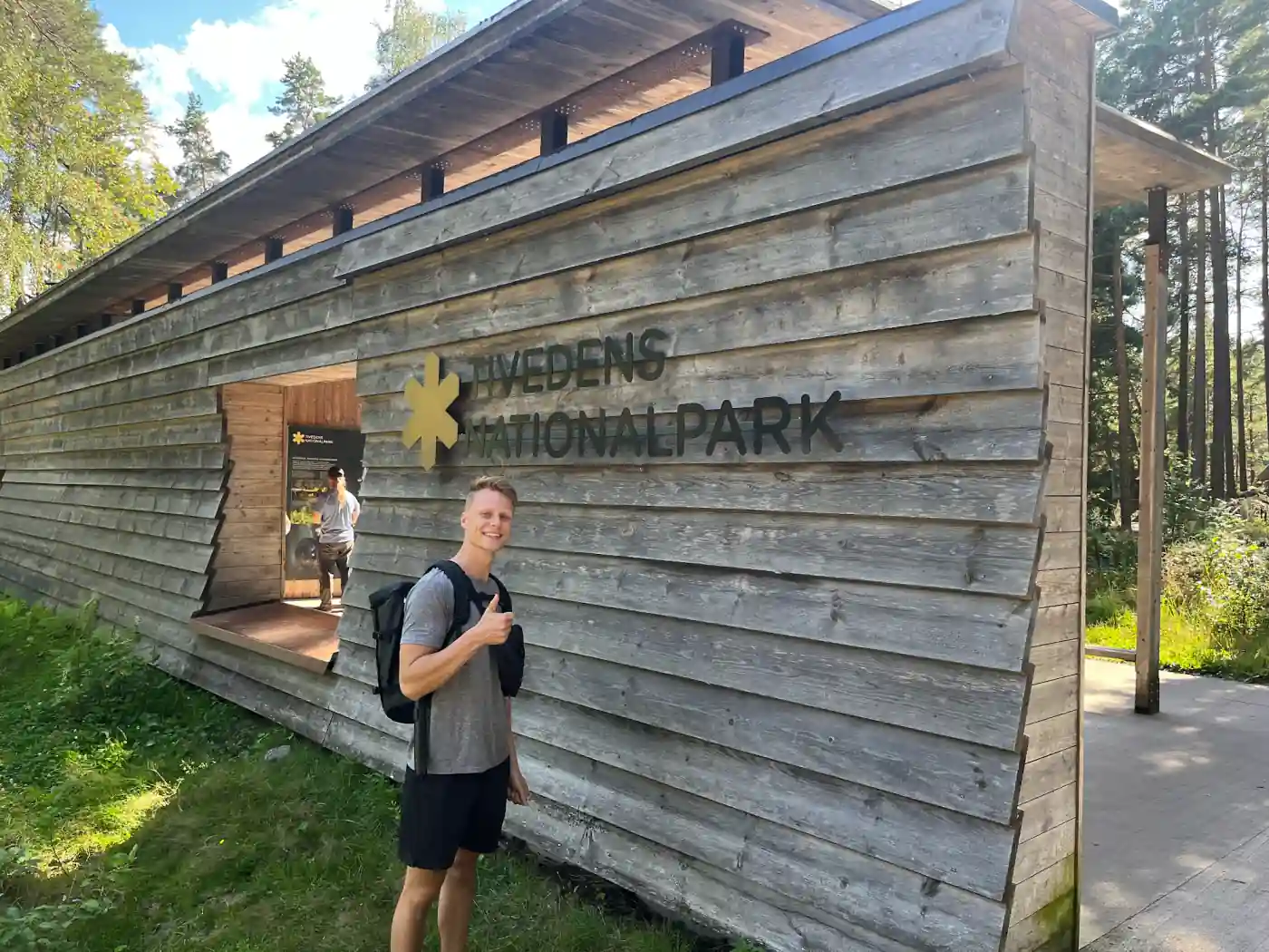 Mark vor dem Holzgebäude am Haupteingang des Tiveden Nationalparks mit dem Schriftzug Tivedens Nationalpark