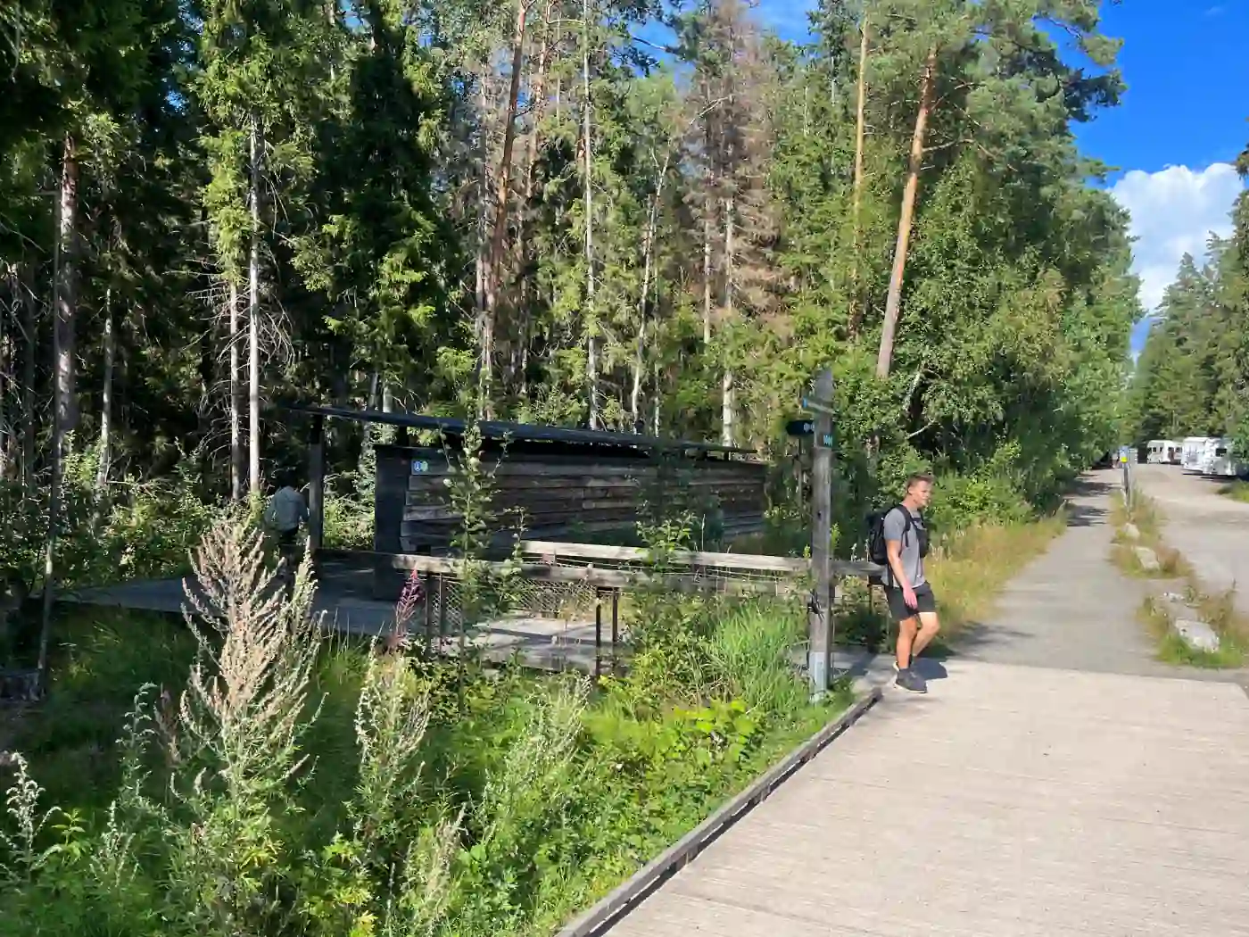 Wegweiser am Haupteingang des Tiveden Nationalparks, im Hintergrund Wohnmobile auf dem Parkplatz
