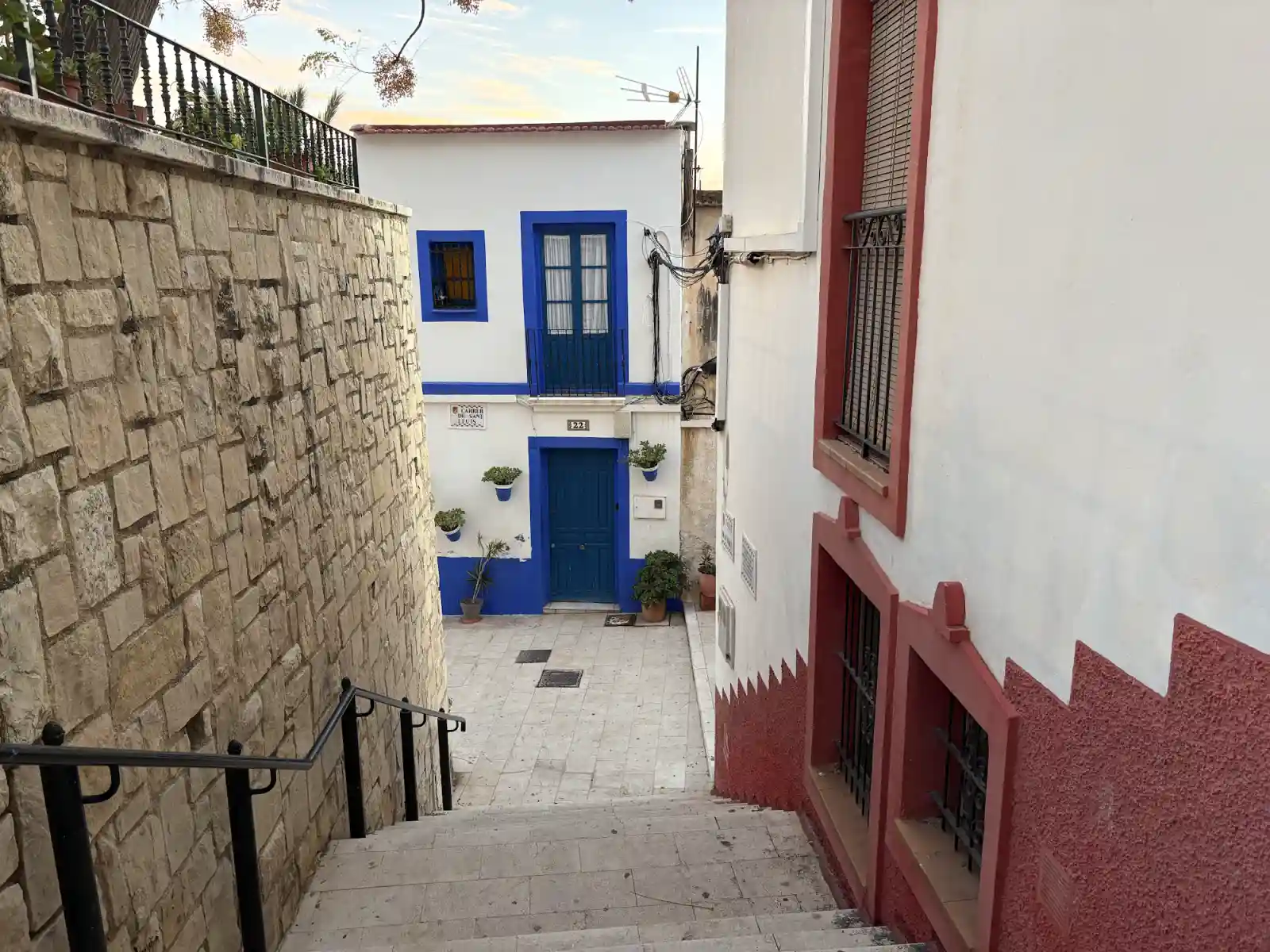 Enge Gasse mit weißen Häusern und blauen Türen im Viertel Santa Cruz