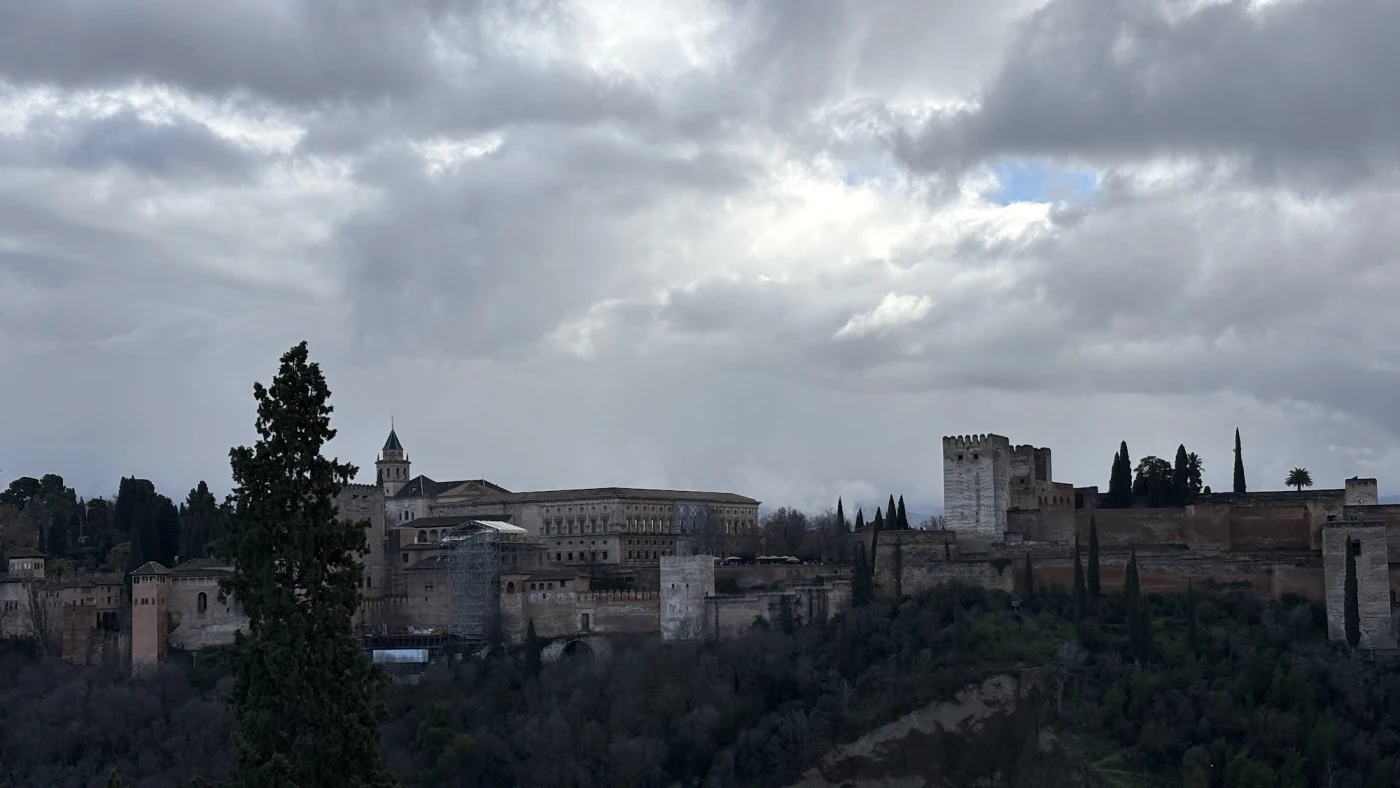 Blick vom Mirador de San Nicolás auf die Alhambra unter einer geschlossenen grauen Wolkendecke