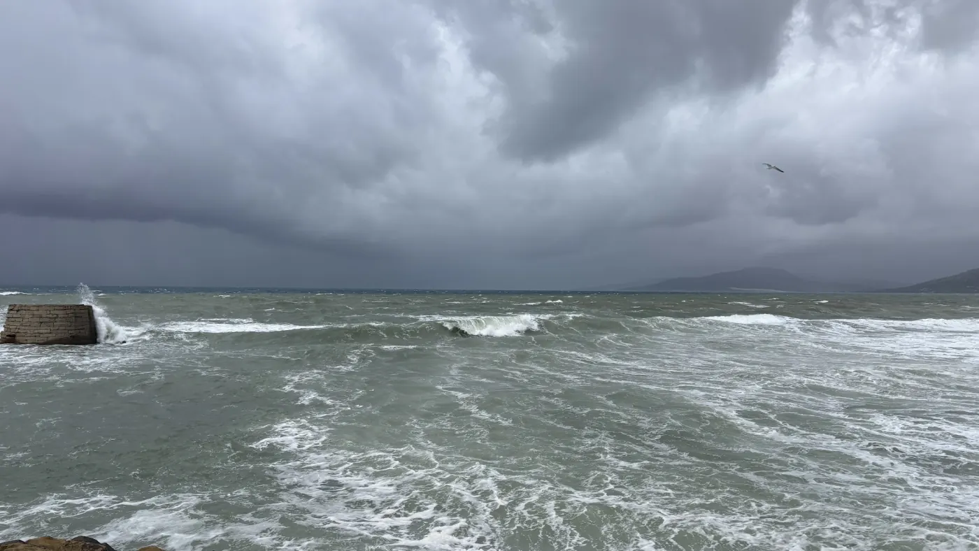 Aufgewühlte Atlantikwellen an einer Mole unter einer dunklen Sturmwolkenfront
