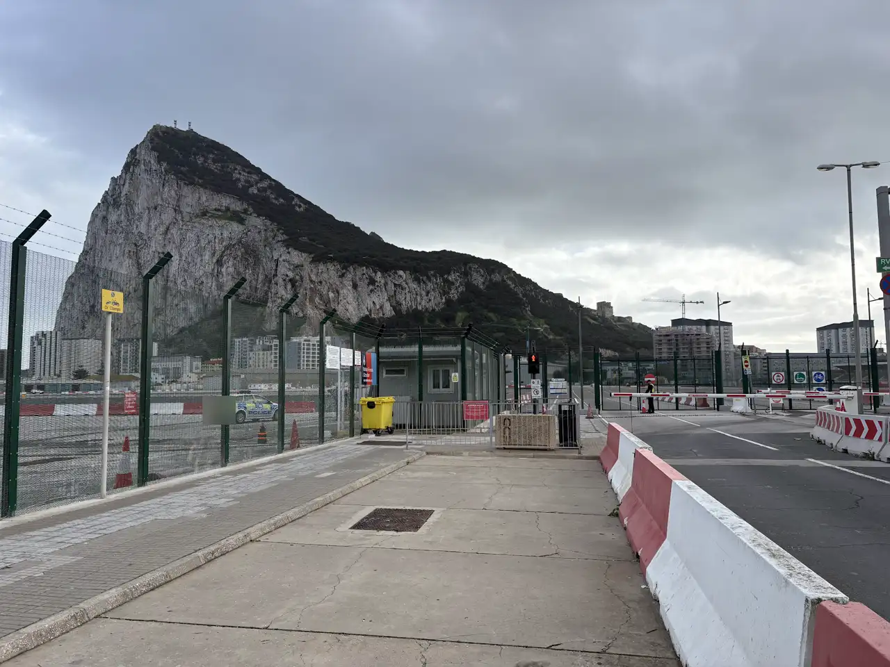 Der Felsen von Gibraltar hinter dem Grenzübergang, davor ein Fußweg mit rot-weißen Absperrungen