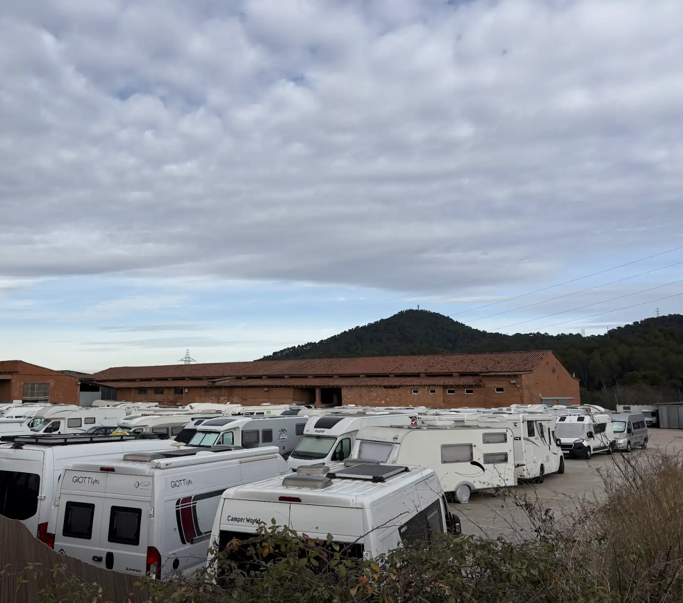 Dicht an dicht geparkte Wohnmobile auf einem Stellplatz im Umland von Barcelona