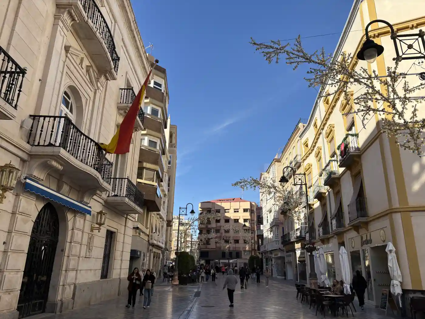 Fußgängerzone in der Altstadt von Cartagena mit hohen Altbaufassaden, Straßenlaternen und Cafés