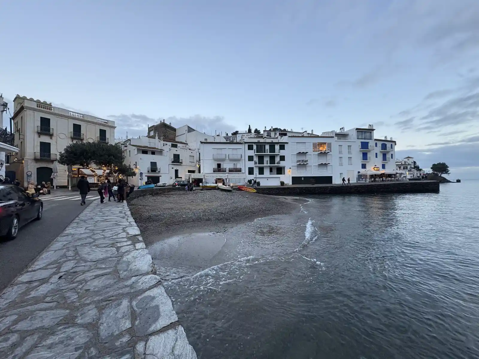 Hafen von Cadaqués in der Abenddämmerung mit weißen Häusern und Booten