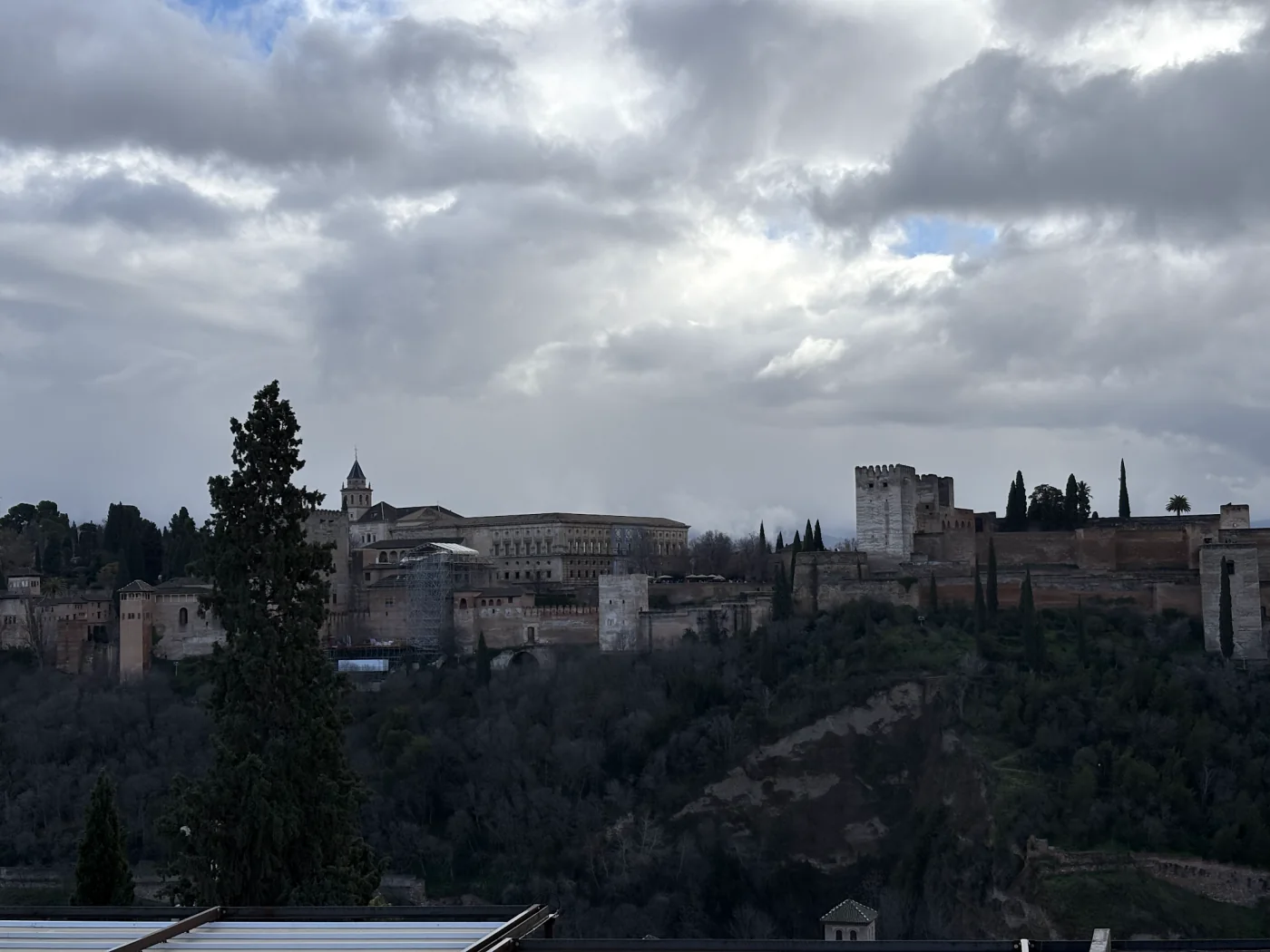 Blick vom Mirador de San Nicolás auf die Alhambra in Granada unter bewölktem Himmel