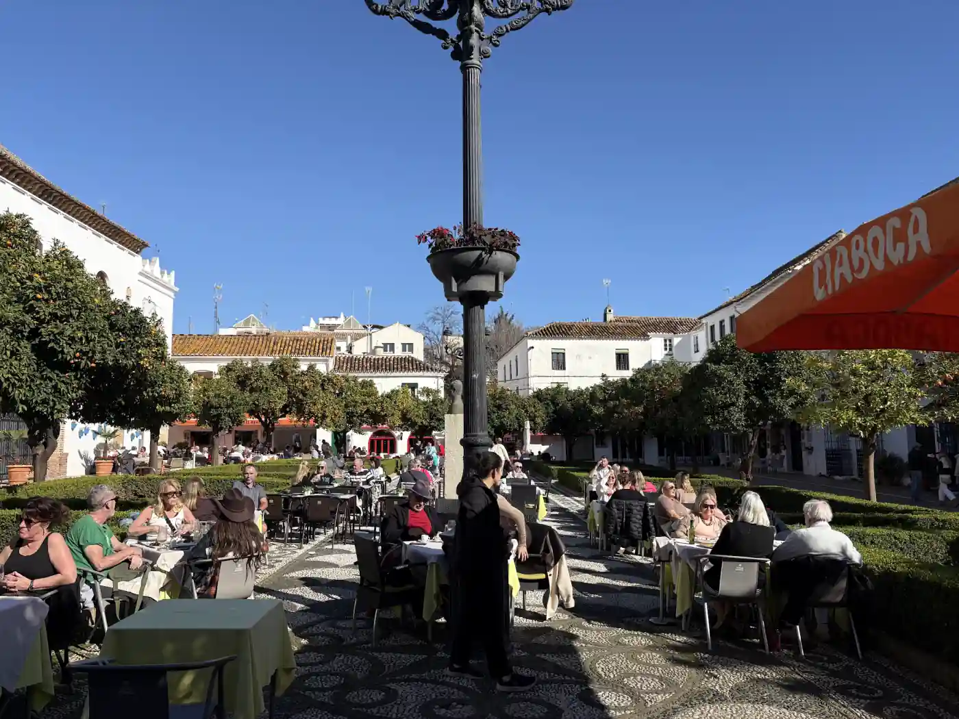 Die Plaza de los Naranjos in Marbella mit Orangenbäumen, Außengastronomie und weißen Häusern