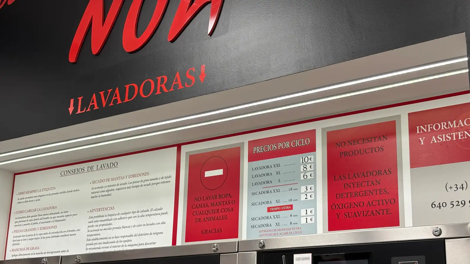 Preistafel in einem spanischen Selbstbedienungs-Waschsalon mit den Preisen pro Waschgang und Trocknergang