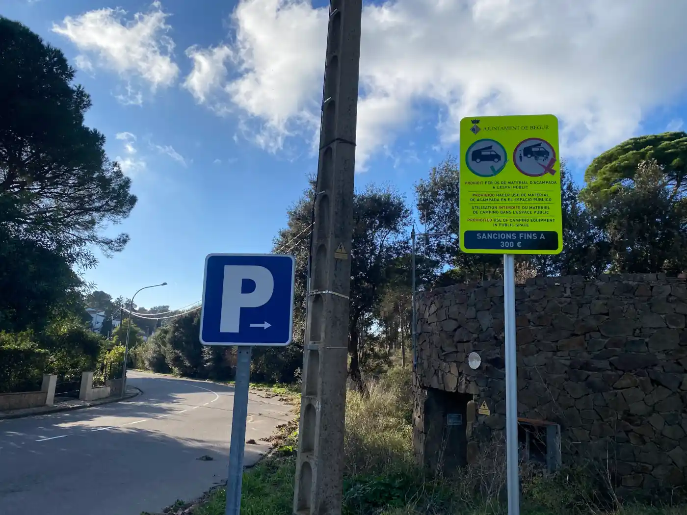 Viersprachiges Schild der Stadt Begur an der Costa Brava, das Campingausrüstung im öffentlichen Raum verbietet und Sanktionen bis 300 Euro ankündigt
